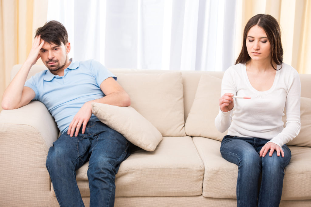 Disappointed couple hoping for a positive pregnancy test