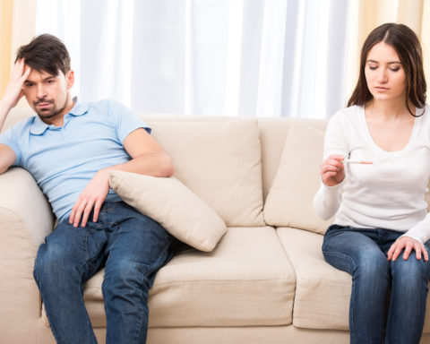 Disappointed couple hoping for a positive pregnancy test