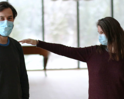 A couple with masks measuring the distance between themselves