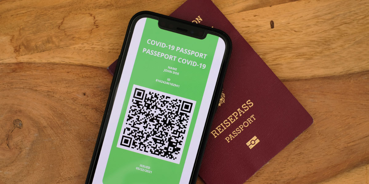 Mobile phone with COVID passport screen and paper passport