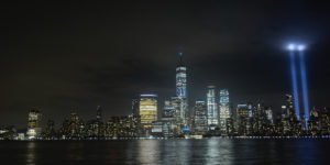 Shot of Manhattan at night pcutred from New Jersey, with blue beams representing the WTC Twin Towers