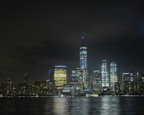 Shot of Manhattan at night pcutred from New Jersey, with blue beams representing the WTC Twin Towers