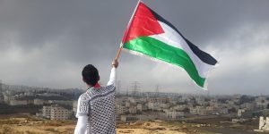 Young man with Palestinian flag overlooking Gaza
