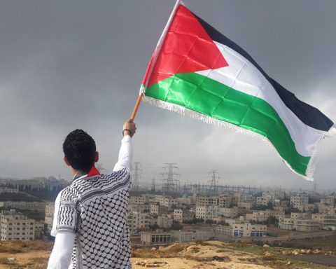 Young man with Palestinian flag overlooking Gaza