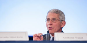a picture of dr anthony fauci sitting at a table